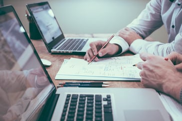 Person writing down how digital asset management software improves content production. 